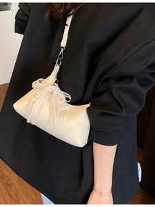 Sac à bandoulière crème chic avec nœud en dentelle blanche et perle porté par mannequin