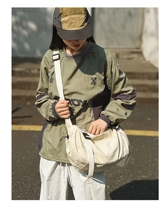 Streetstyle-Ansicht einer großen beigen Umhängetasche kombiniert mit lässigem Outdoor-Outfit