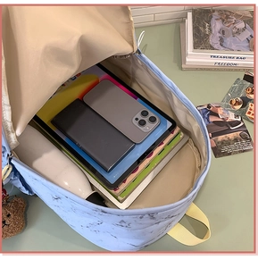 Detalle del interior de la mochila con estampado de mármol y espacio para portátil