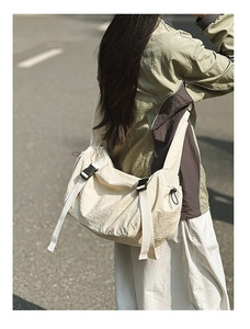 Makroaufnahme der cremefarbenen Nylon-Tasche mit schwarzer Schnalle und Kordelzug-Detail