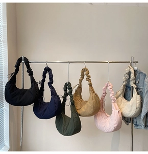 Detail of ruched shoulder straps on minimalist crescent hobo bags in six varied colors