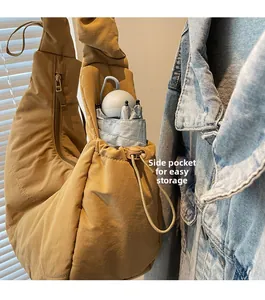 Nylon quilted dumpling bag detail showing side drawstring pocket with a folded umbrella