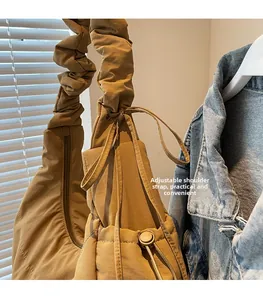 Detail of khaki shoulder bag featuring adjustable ruched strap and textured fabric