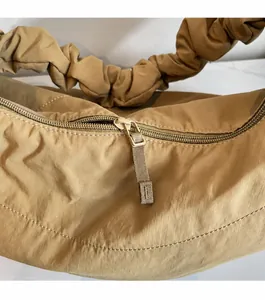 Detail of smooth khaki nylon bag zipper and stylish ruched shoulder strap design