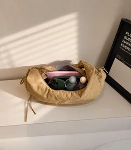 Spacious interior of khaki shoulder bag showing storage for tablet, phone, and umbrella