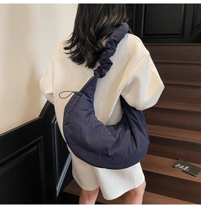 Quilted navy blue hobo bag showing large capacity and ruched strap detail on a model