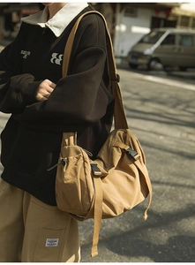Detail der khakifarbenen Tasche mit verstellbarem Gurt und schwarzer Schnalle