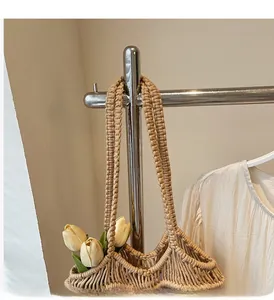 Détail du sac cabas tissé beige avec motifs ajourés et poignées tressées épaisses