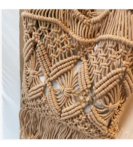 Détail d'un sac de plage en crochet kaki fait main avec motifs ajourés et longues franges