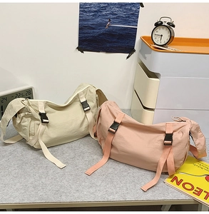 Detailansicht der Nylon-Umhängetaschen in Creme und Rosa mit verstellbaren Schnallen