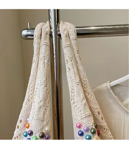 Close-up of knit shoulder strap featuring colorful beads and hollow-out crochet detail