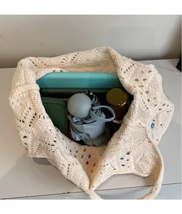 Macro view of beige crochet tote bag showing large capacity for umbrella and notebook