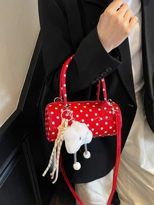 Red polka dot cylinder crossbody bag with white dots and plush cloud charm accessory