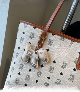 Dettaglio della borsa tote off-white con motivi di orsi e ciondolo a cucciolo