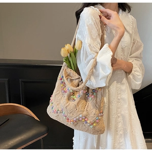 Detail of beige crochet tote bag featuring colorful beadwork and floral styling