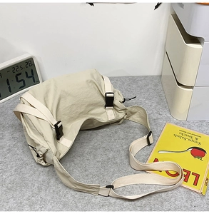 Detail der beigen Nylon-Umhängetasche mit Kordelzugverschluss und Kunststoffschnalle