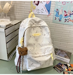 Mochila con patrón de mármol blanco, asa amarilla y colgante de oso de peluche