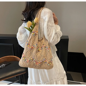 Detail view of beige knit tote bag with colorful beads and decorative tulips inside