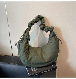 Detail of army green quilted nylon dumpling bag with pleated strap and side drawstring