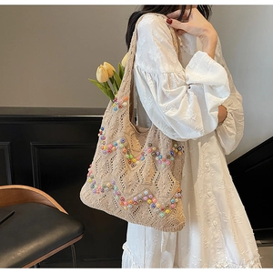 Detail of beige knit tote bag with colorful beads and hollow crochet texture