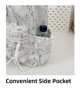 Detail view of the backpack side pocket holding a water bottle with marble texture print