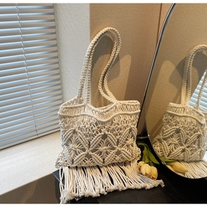 Détail du sac de plage en macramé crème avec motif ajouré et finitions à franges