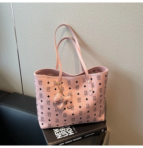 Dettaglio della borsa tote rosa con monogramma e ciondolo a forma di cane carino