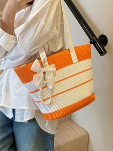 Bolso de playa grande a rayas naranjas de paja con colgante de perlas y lazo