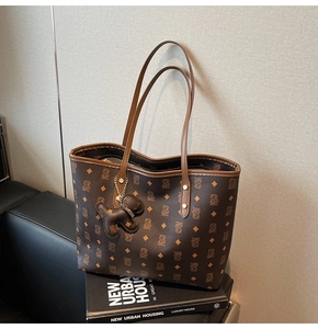 Dettaglio della borsa tote monogram con ciondolo a forma di cucciolo in pelle
