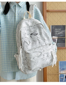 Detail of grey marble pattern backpack with side pockets and braided zipper pull