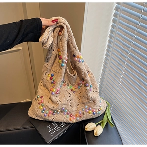 Detailed view of beige knit tote bag featuring colorful pearl beads and hollow weave texture