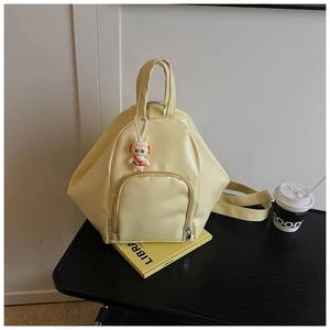 Detail of yellow geometric tote bag featuring astronaut bunny charm and sleek PU texture