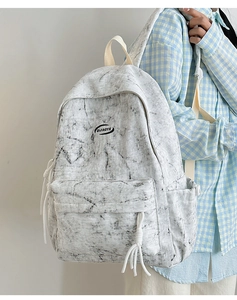 Detail view of marble pattern canvas backpack with front zipper and brand logo