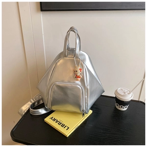 Detailed macro view of silver geometric backpack with mirror finish and cute bunny charm