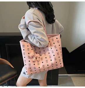 Dettaglio borsa tote rosa con motivi di orsi e ciondolo in pelle a forma di cane
