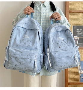 Detail of light blue marble print backpacks in two sizes with OIJIAOYE branding logo