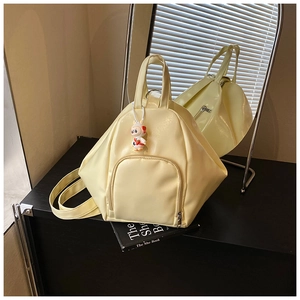 Detail of light yellow multifunctional tote bag with geometric design and cute rabbit charm