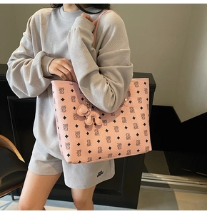 Dettaglio borsa tote rosa con motivo a rombi e orsetti e charm elefante in pelle