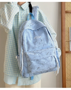 Close-up of light blue marble pattern backpack with rope knot zipper details on a model