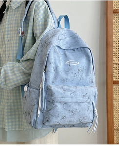Close-up of light blue marble backpack with durable zipper and elastic side pocket