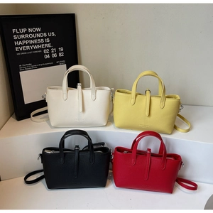 Detailed close-up of textured leather tote bags in beige, yellow, black, and red colors