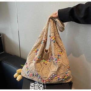 Detail of hollow knit tote bag with colorful bead accents and bohemian crochet texture