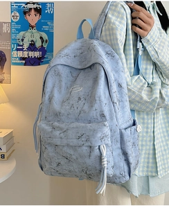 Detail of light blue marble pattern backpack with woven zipper pulls and side pockets
