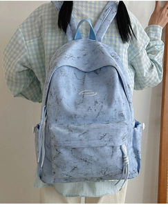 Close-up of light blue marble pattern backpack with zipper details and side pocket