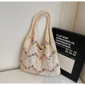 Detail of hollow knit tote bag featuring colorful faux pearl beads in wave patterns