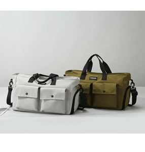 Detail of travel bags with front flap pockets, sturdy handles and fashion logo patch