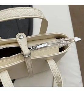 Detailed macro view of the smooth silver metal zipper and textured lychee pattern leather