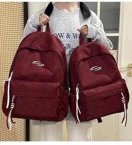 Detail of burgundy backpacks with matte texture and decorative white tassel zippers