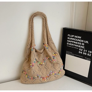 Close-up of beige knitted tote bag featuring colorful bead patterns and hollow texture