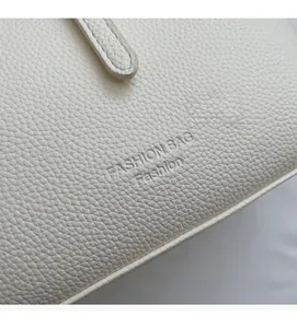 Detailed macro view of white lychee grain leather texture and fine corner stitching